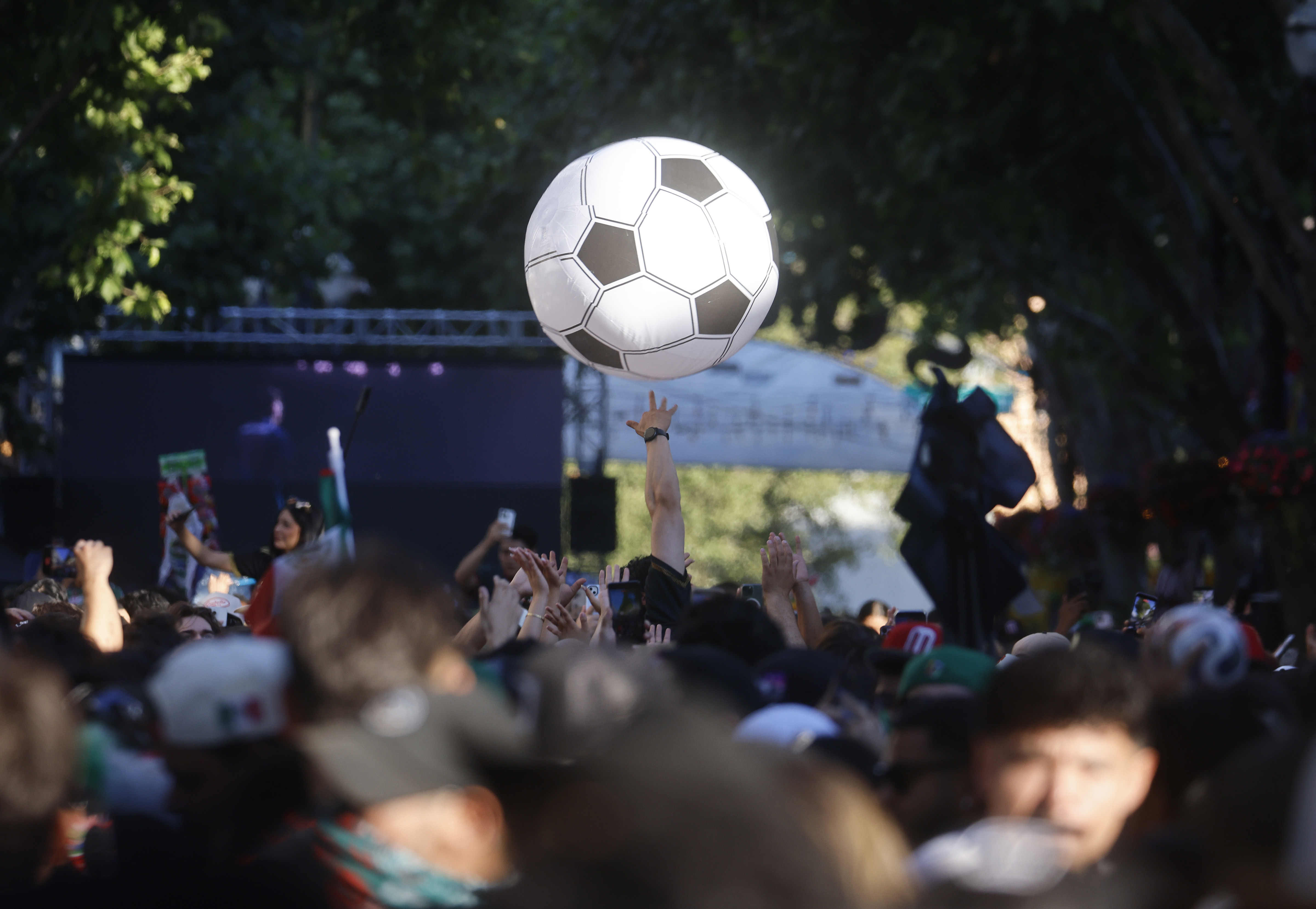 Soccer fans play with a large inflatable ball as they...