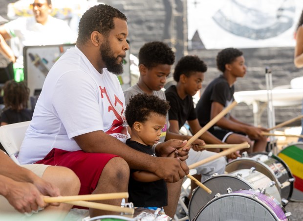 Anthone Jackson and his son Amanee, 1, learn how to play the drums during a workshop at the Juneteenth celebration, Saturday, June 15, 2024, in the SoFa District of San Jose, Calif. (Karl Mondon/Bay Area News Group)