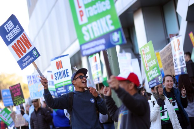 Wesley Briones, center, a physical therapist takes part in a picket line outside of the Kaiser Oakland Medical Center on Monday, Jan. 26, 2026, in Oakland, Calif. Thousands of striking workers, who are represented by United Nurses Associations of California/Union of Health Care Professionals, are expected to strike indefinitely amid stalled labor negotiations. (Aric Crabb/Bay Area News Group)