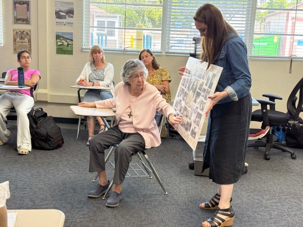 Sister Rosalie Pizzo, a 1952 graduate of Notre Dame San Jose, looks at a historical display held by social studies teacher Emily Cardenas, who is leading a project to celebrate the high schools' 175th anniversary this year. (Courtesy Notre Dame High School)