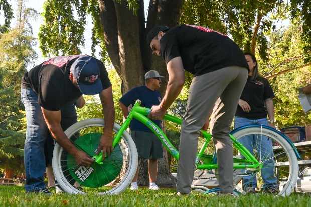 San Jose firefighters assemble a bicycle for donation at the Taco Tuesday collection drive for farmworkers at History Park in San Jose. (J.R. McMinn/Mosaic)
