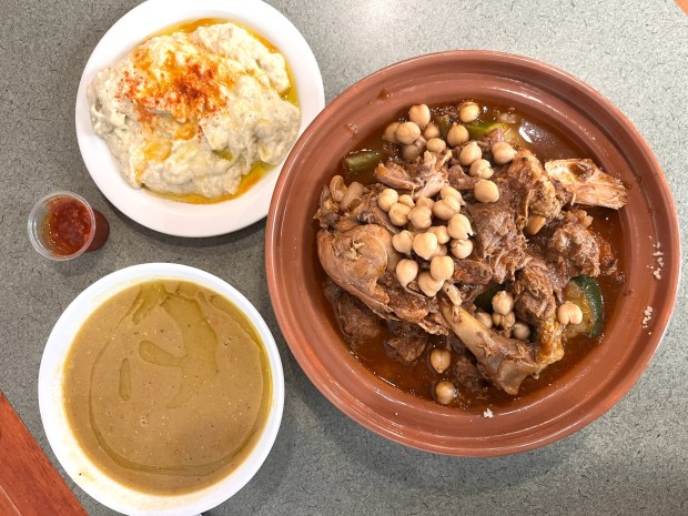The mixed couscous with chicken, lamb, carrots, zucchini, kale and chickpeas is pictured with lentil soup and baba ghanoush in May 2026 at Gusto restaurant in Berkeley, Calif. (John Metcalfe/Bay Area News Group)