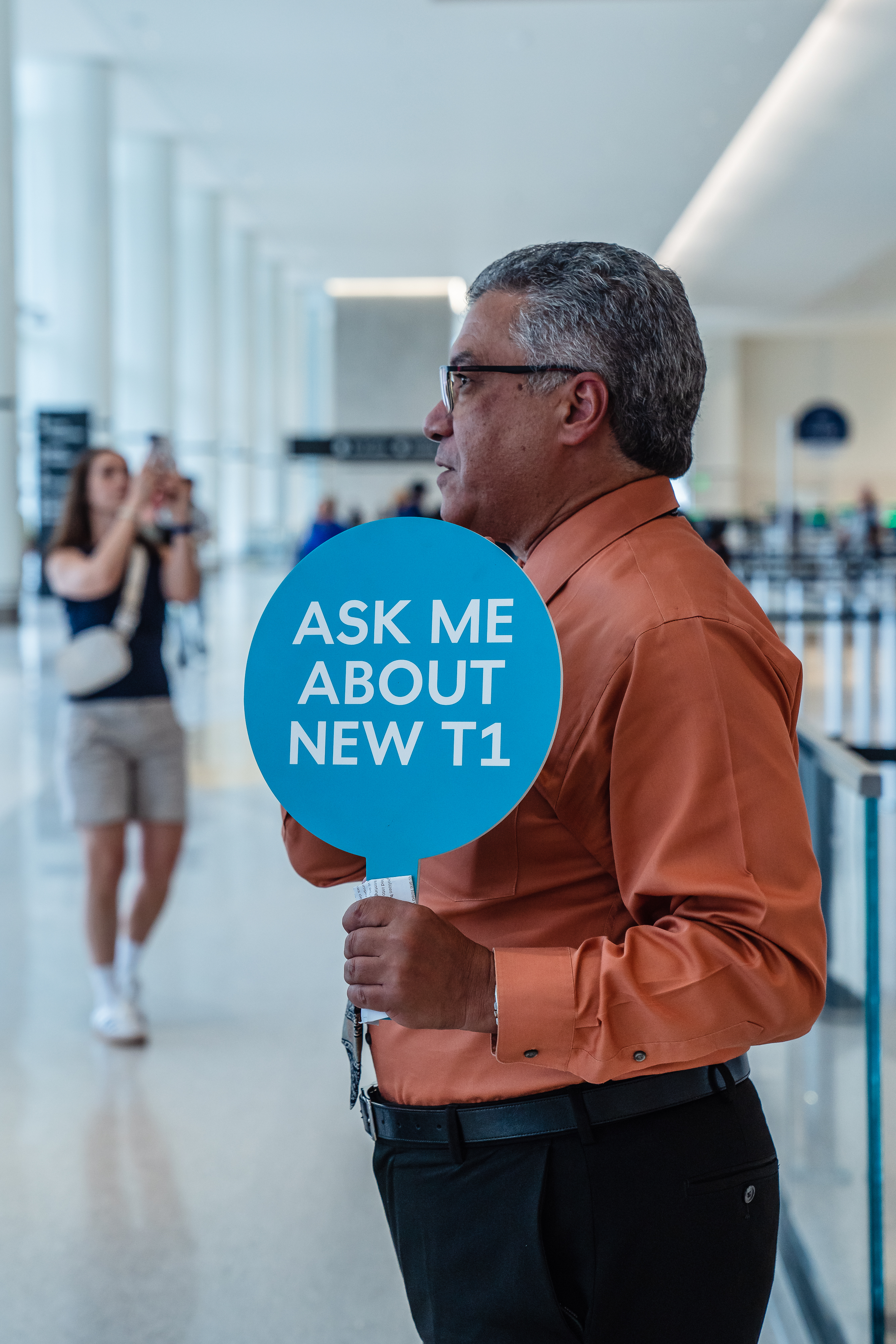 Mo Mokled holds a sign âAsk Me About New T1...