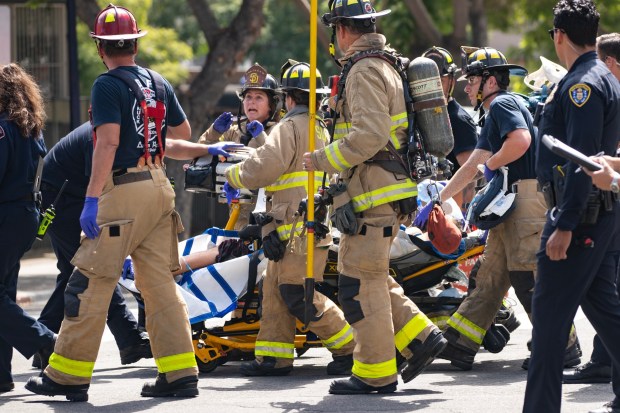 San Diego, CA - Fire, Police and EMS wheel the suspect to an ambulance at the corner of Cedar and 6th Avenue on Tuesday, June 23, 2026, in San Diego, CA. The suspect was allegedly shot by police after barricading himself in his apartment. (Luke Johnson / The San Diego Union-Tribune)DNP - NEEDS EDITOR APPROVAL GRAPHIC CONTENT