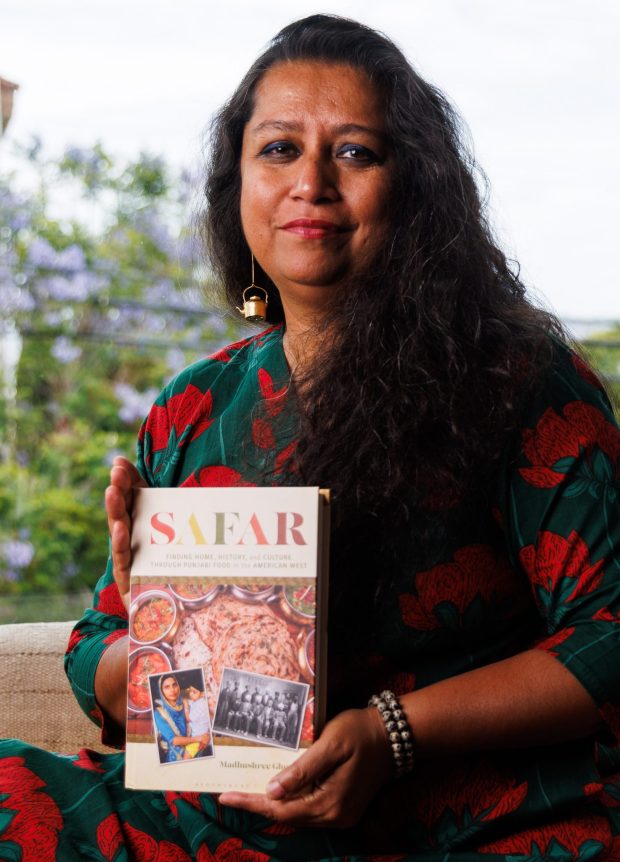 Author Madhushree Ghosh poses with her new book, "Safar," at her Mission Hills home on Wednesday, May 27, 2026. The book explores the culture surrounding Punjabi food in the American Southwest. (Kristian Carreon / The San Diego Union-Tribune)