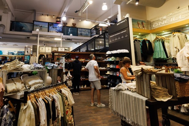 Shoppers at Sun Diego Boardshop in Mission Beach on Friday, June 12, 2026. The store features clothes from multiple surf brands. (Kristian Carreon / The San Diego Union-Tribune)