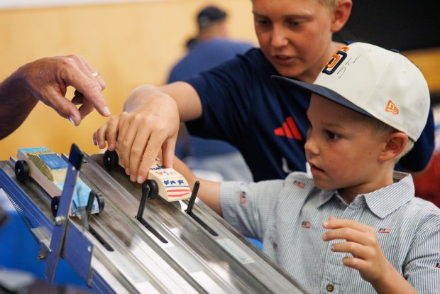 Todd Gretler, 14, and Luke Gretler, 9, set up their toy car to race during the USA 250 festival in Oceanside on Saturday, June 27, 2026. (Kristian Carreon / The San Diego Union-Tribune)