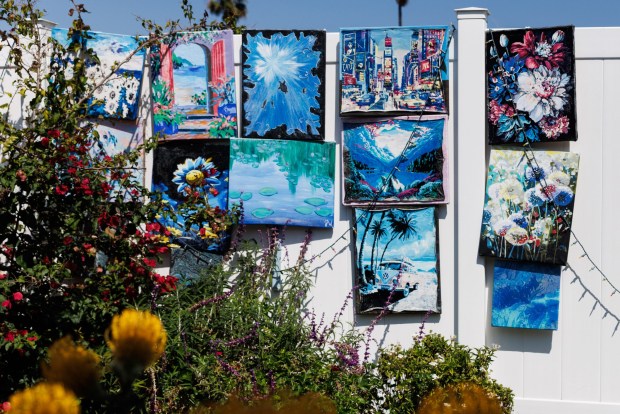 Julie Wilhelmy began creating artwork during the coronavirus pandemic. She displays it on a fence, even out in the elements. (Kristian Carreon / The San Diego Union-Tribune)