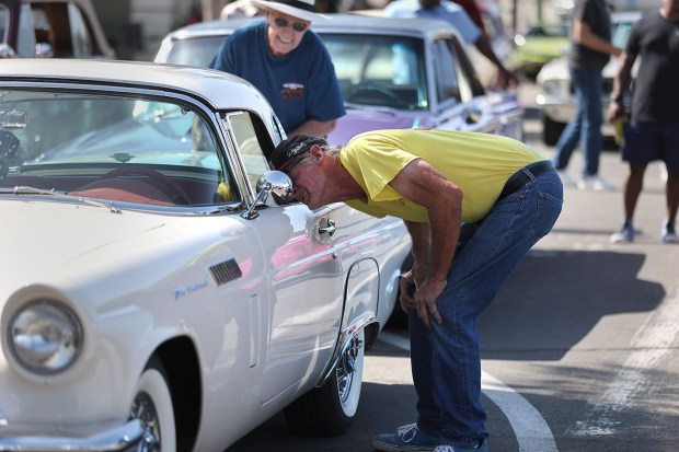 Escondido, CA 6_5_2026_|Mike Zellmer of Escondido takes a closer look at someone's 1957 Ford Thunderbird, his wife has a 1958 model. |Escondido's first Cruising' Grand of 2026 features vintage cars (1973 and older) and a street fair. (John Gastaldo / For The San Diego Union-Tribune)
