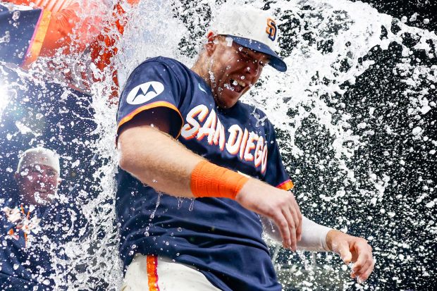 Jackson Merrill and Ty France douse Gavin Sheets after his walk-off homer against the Colorado Rockies during the ninth inning at Petco Park on Friday, April 10, 2026 in San Diego, California. (Meg McLaughlin / The San Diego Union-Tribune)