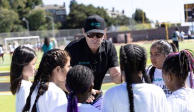 Steve Young huddles with young female athletes