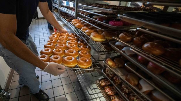 Staff members stock glazed doughnuts at Randy's Donuts in Pasadena.. (2024 photo by Sarah Reingewirtz, Los Angeles Daily News/SCNG)