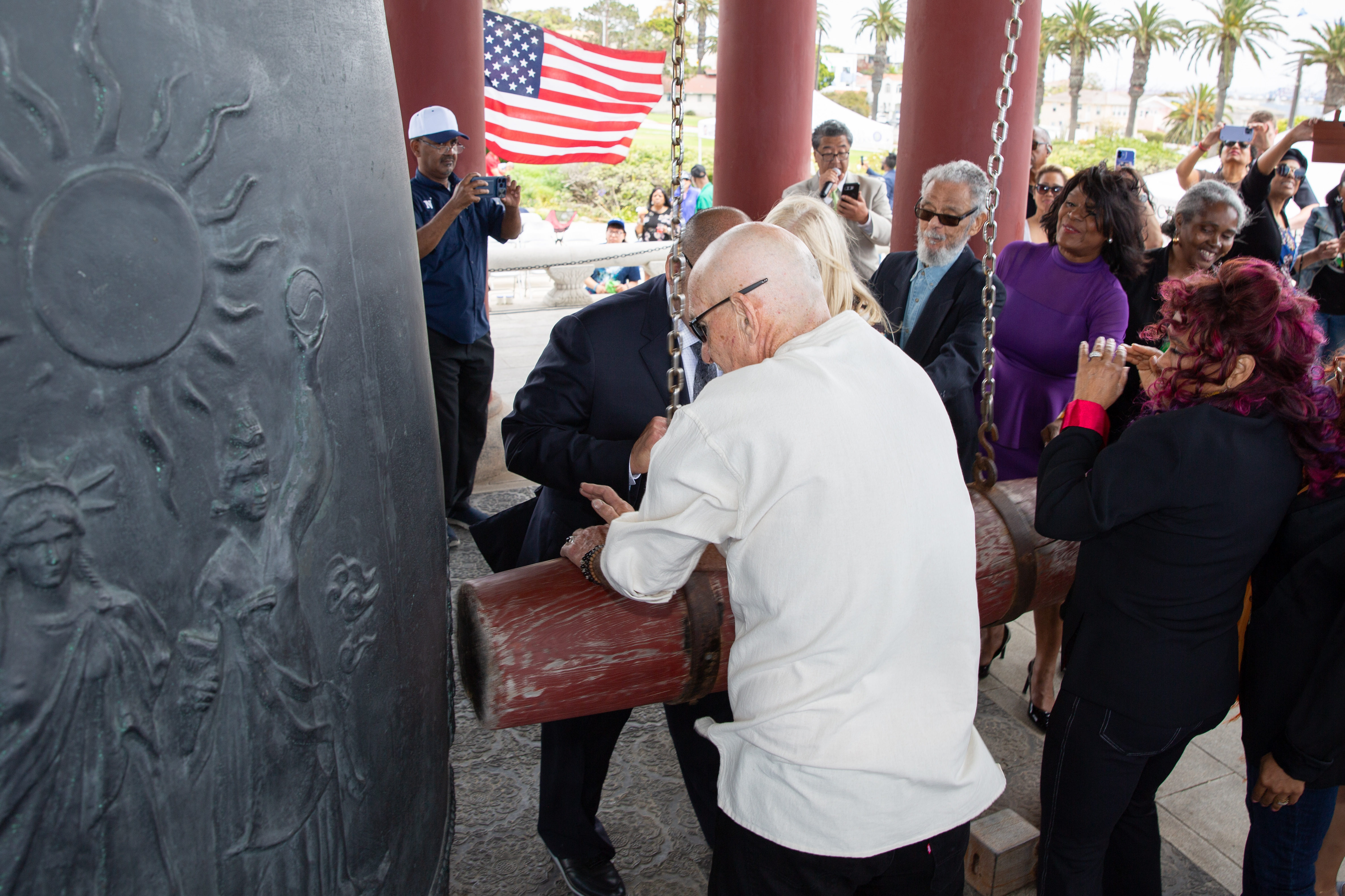 Officials and guests ring the bell during a Juneteenth celebration...