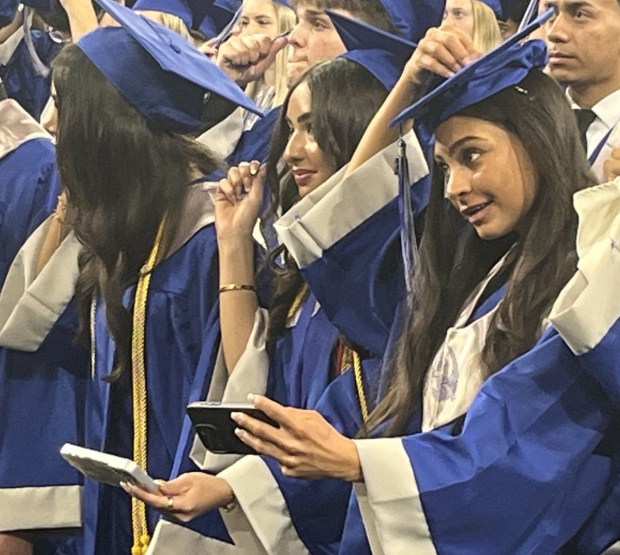 Smiling Eisenhower High School students turn their tassels at the school's commencement ceremony at Oakland University in Rochester. (COURTESY UTICA COMMUNITY SCHOOLS)
