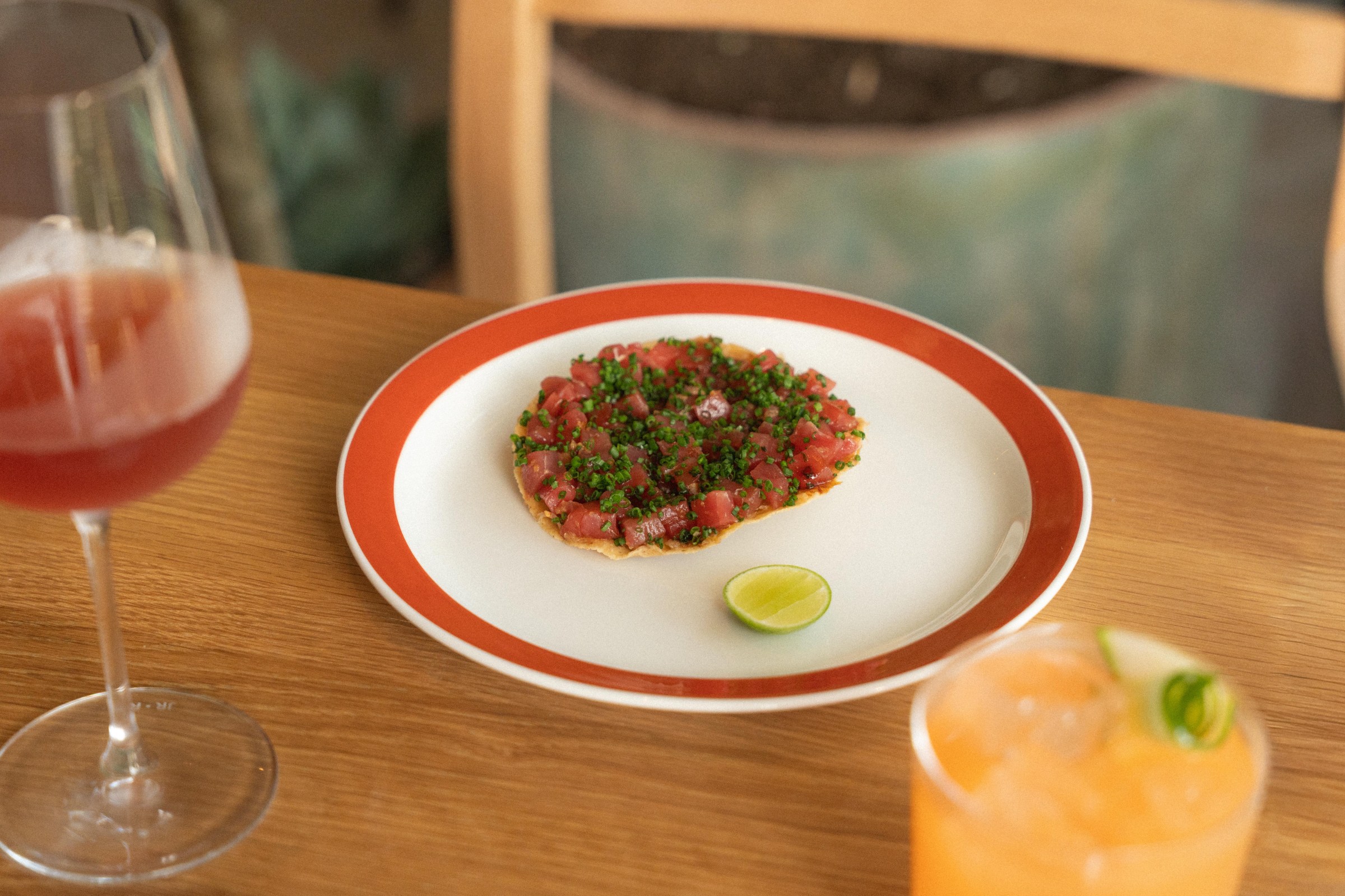 Tuna tostada at San Damian with a glass of wine in the foreground.