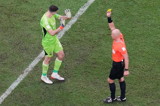 FILE - Referee Szymon Marciniak, of Poland, shows a yellow card to Argentina's goalkeeper Emiliano Martinez during the penalty shootout inthe World Cup final soccer match between Argentina and France at the Lusail Stadium in Lusail, Qatar, Sunday, Dec. 18, 2022. (AP Photo/Thanassis Stavrakis, File)