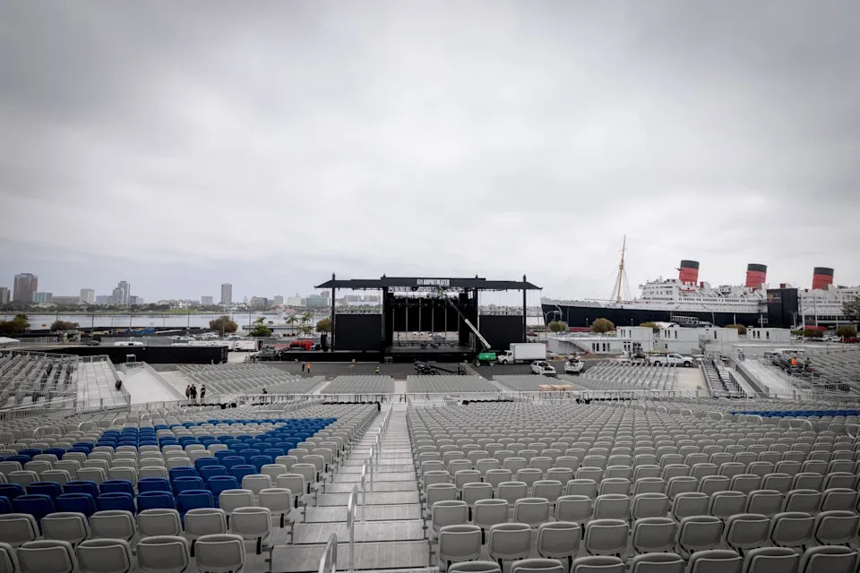 A view of seats leading up to a stage with a construction vehicle parked in front.