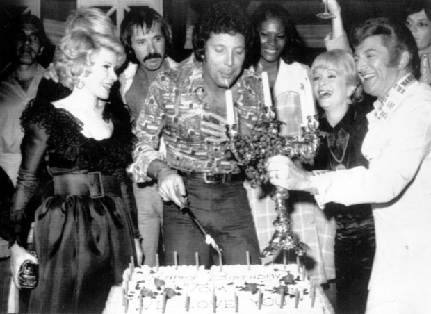 Veteran singer Tom Jones, 86, will perform at The Shell this fall.. He is shown in this photo at center, blowing out candles at a surprise birthday party for him at Caesar's Palace in Las Vegas on June 6, 1974. Guests include, from left to right, Joan Rivers, Sonny Bono, Jones, Debbie Reynolds and Liberace. (AP Photo)