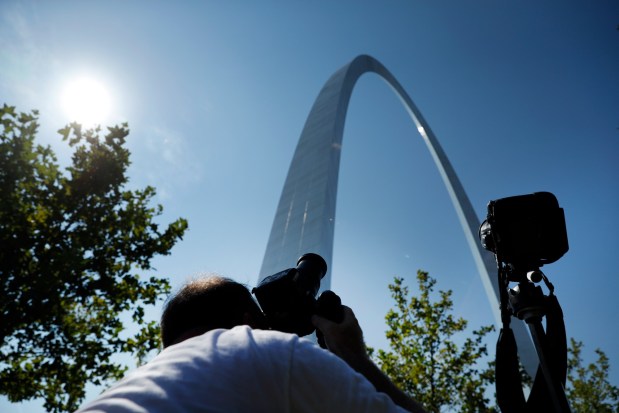 Jason Arbaugh, of Austin, lines up his shot for the solar eclipse at the Gateway Arch on Monday, Aug. 21, 2017, in St. Louis. (AP Photo/Jeff Roberson)