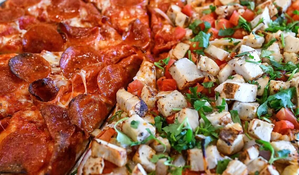 A pizza with half pepperoni and half butter chicken is prepared at The Curry Pizza Company's newest location on Fowler southeast of Belmont in the Sunnyside area of Fresno. This location is the first to have a full bar.