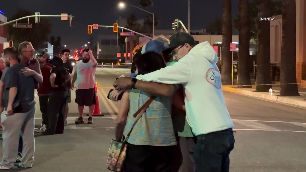 Family and friends embrace in the street following a hostage situation at a Chase Bank.