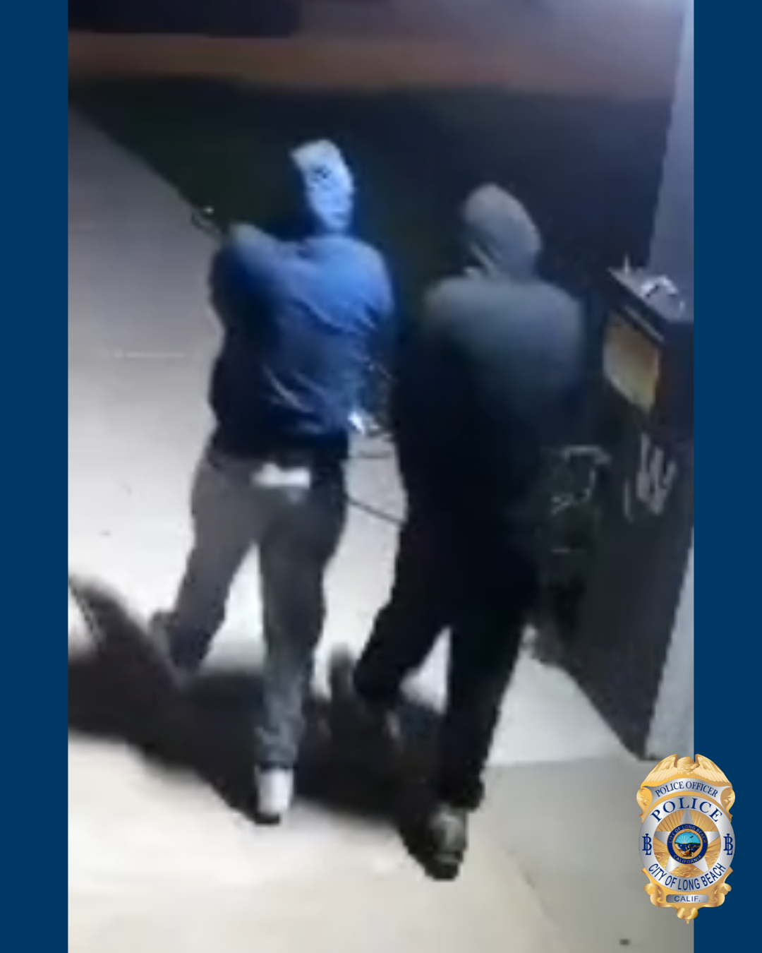 Blurry photo of the backs of two men in dark clothing as they walk on a sidewalk at night.
