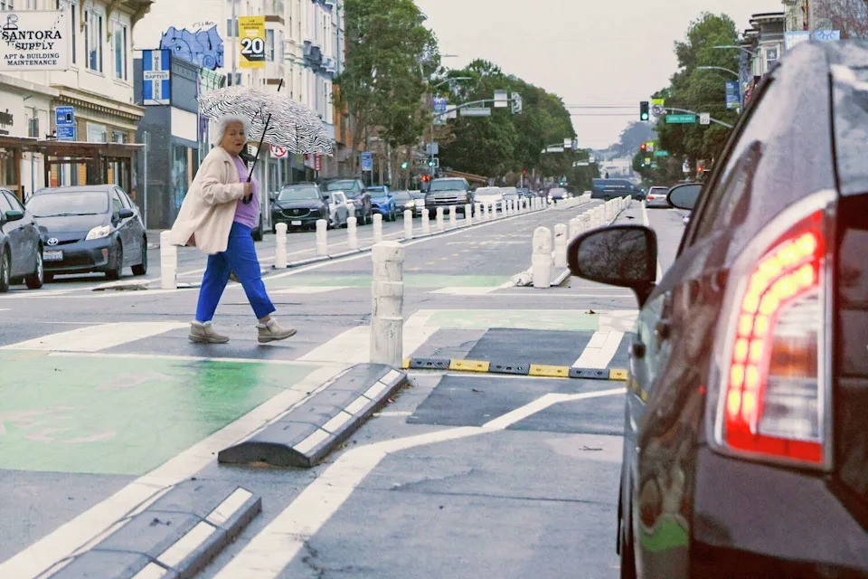 Pedestrians use the crosswalk along 19th Street at Valencia Street in San Francisco. San Francisco wants to make more daylighted corners harder to block - and more attractive. A new pilot lets neighborhood groups add planters and murals, but they'll have to pay a fee, maintain the installations and carry insurance for planters. (Santiago Mejia/The Chronicle)