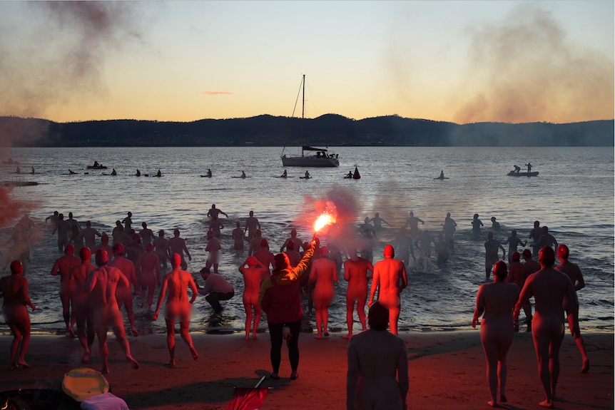 Crowd of swimmers prepare to enter the water for Dark Mofo's 2026 Nude Solstice Swim