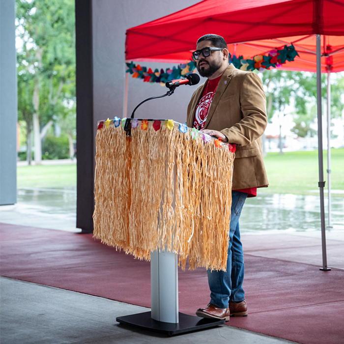 Dr. Jimenez speaking at a podium during luau
