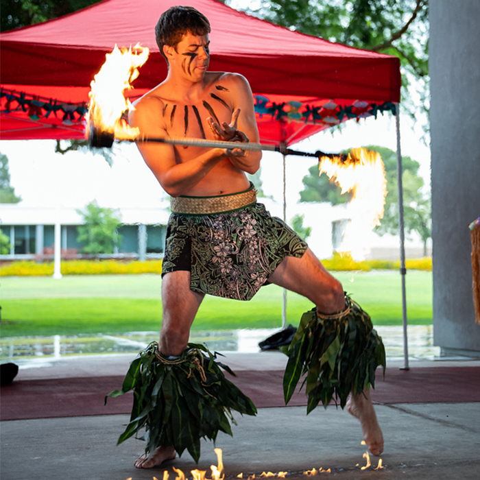 male perfomer with fire sticks during event