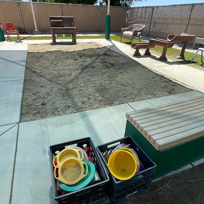 large outdoor sandbox covered by a tent for shade