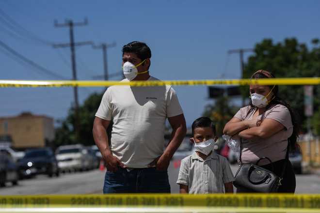 Los Angeles People wear masks while watching firefighters fight a warehouse fire in the Boyle Heights neighborhood of Los Angeles, Sunday, June 21, 2026.