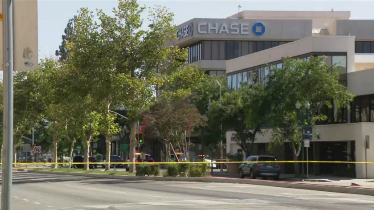 Law enforcement vehicles are parked behind police tape in downtown Bakersfield during an active police response near a Chase Bank.