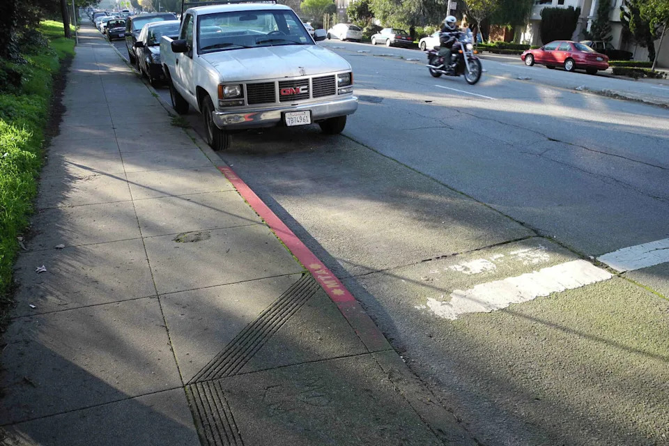 A red curb is seen at Fulton Street and Second Avenue in San Francisco. San Francisco wants to make more daylighted corners harder to block - and more attractive. A new pilot lets neighborhood groups add planters and murals, but they'll have to pay a fee, maintain the installations and carry insurance for planters. (SFMTA)