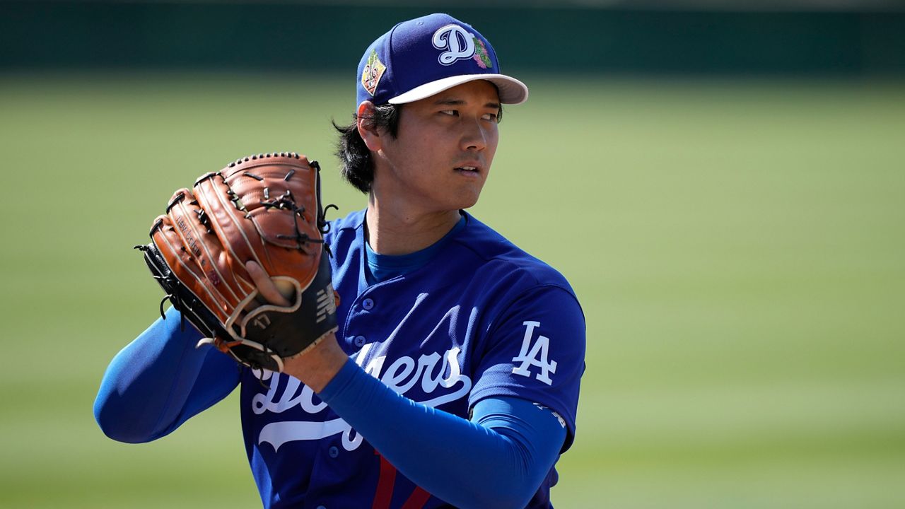 Los Angeles Dodgers two-way player Shohei Ohtani (17) warms up during spring training baseball on Sunday, Feb. 22, 2026, in Phoenix. (AP Photo/Brynn Anderson)