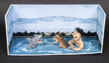 A model featuring a white boy and his dog, chest-deep in the ocean, facing off against a cartoonish-looking shark.