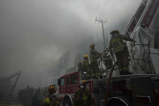 Firefighters Firefighters work from a ladder truck while fighting a warehouse fire in the Boyle Heights neighborhood of Los Angeles, Sunday, June 21, 2026.