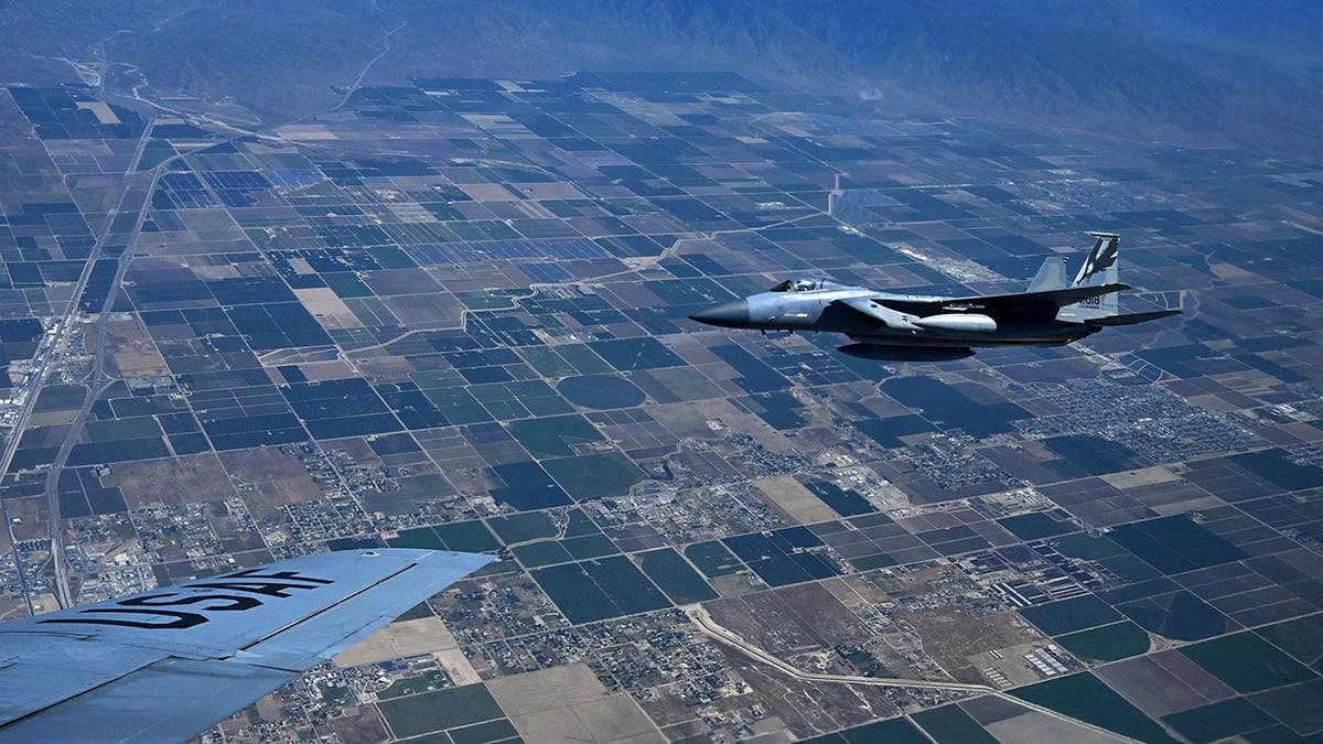 An F-15 flying beside a Boeing KC-135 Stratotanker performing simulated refueling near March Air Reserve Base