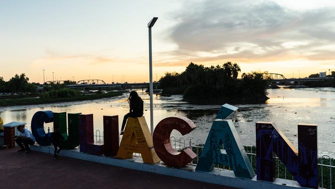A person sits on top of a city sign at Las Riberas Park in Culiacan, Sinaloa state, Mexico, on Sunday, Oct. 27, 2019.