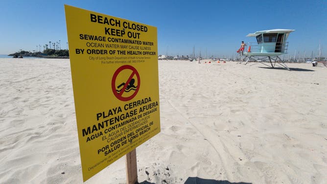 LONG BEACH, CA - APRIL 21: A sign warns people to stay out of the water at Alamitos Beach in Long Beach on Friday, April 21, 2023. This follows a sewage spill on Thursday in Downey that flowed into storm drains and out to sea.
