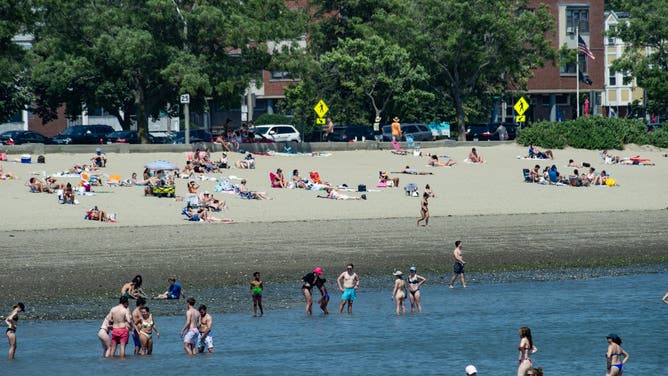People take refuge at Carson beach from the blazing sun during a heatwave in Boston, Massachusetts, on June 19, 2024. Extreme heat and high humidity smothered the central and northeastern US on June 18, 2024, with temperature records expected to melt away in the coming days, authorities warned. Forecasters predicted temperatures could hit 100 degrees Fahrenheit (about 38 Celsius) in parts of New England by June 20.
