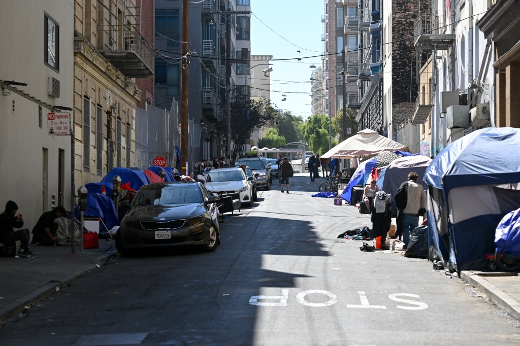 A street in San Francisco's Tenderloin District is filled with homeless encampments and people.