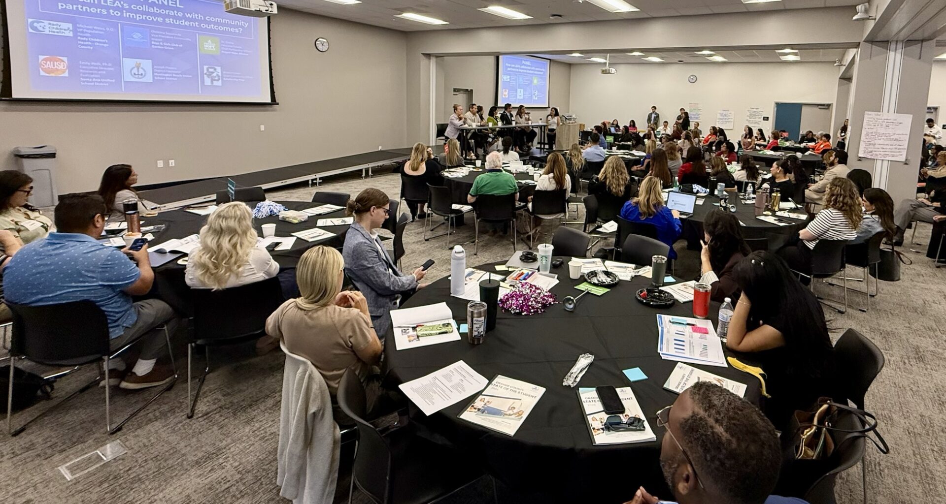 Participants sit at round tables during the State of the Student Forum at the OCDE Conference Center in Costa Mesa while listening to a panel discussion and presentation about student outcomes and community partnerships.