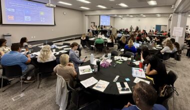 Participants sit at round tables during the State of the Student Forum at the OCDE Conference Center in Costa Mesa while listening to a panel discussion and presentation about student outcomes and community partnerships.