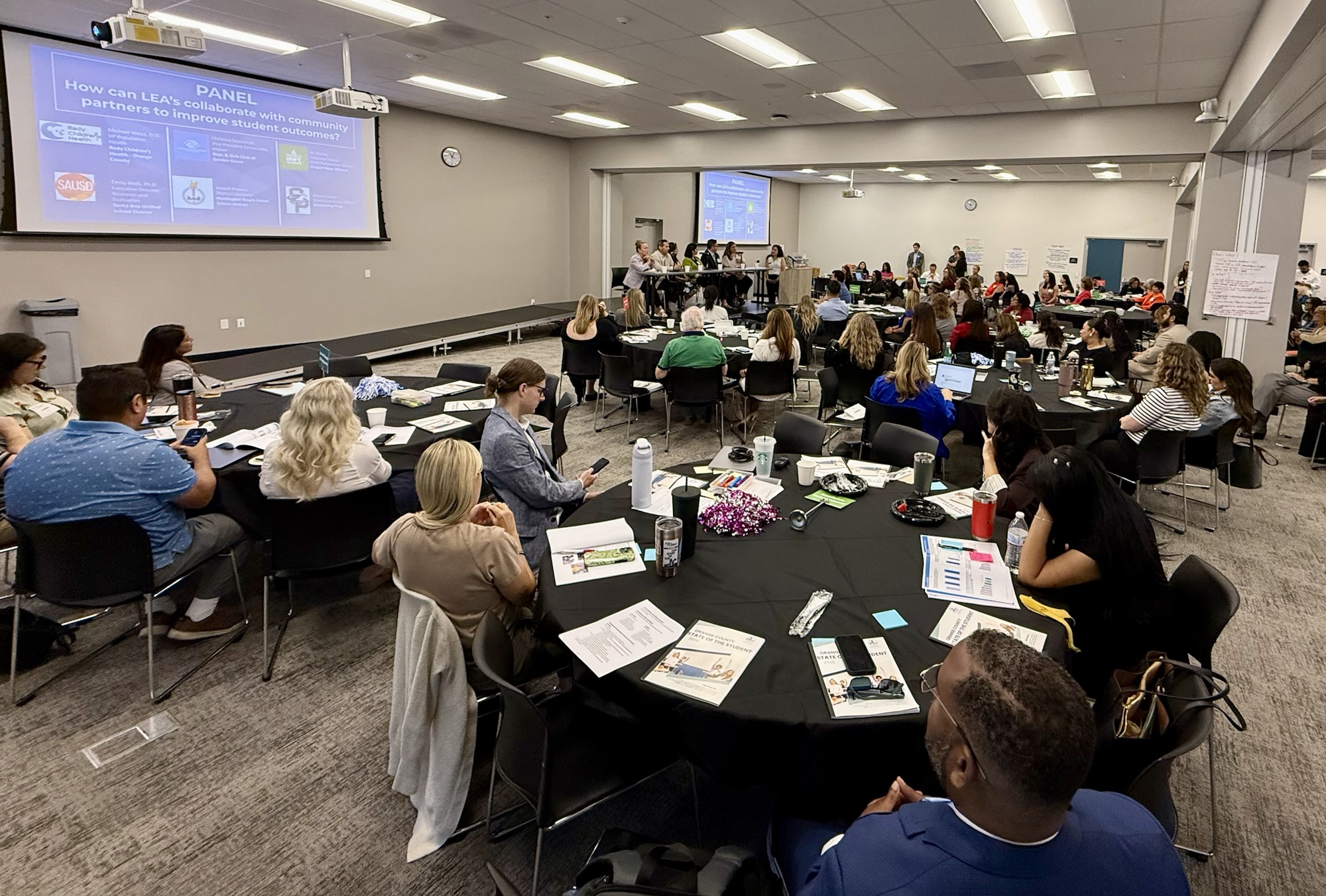 Participants sit at round tables during the State of the Student Forum at the OCDE Conference Center in Costa Mesa while listening to a panel discussion and presentation about student outcomes and community partnerships.