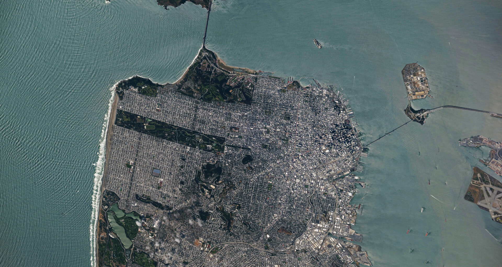 A view of downtown San Francisco from the International Space Station. The city's streets are visible in the daylight, as well as the Golden Gate Bridge to the north and the San Francisco-Oakland Bay Bridge connecting to Oakland to the east.