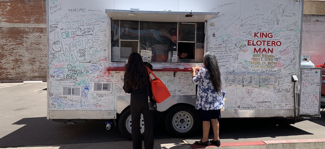 Two customers order from the King Elotero Man food truck during the Fresno Area Hispanic Foundation’s Mobile Food Vendor Grant Ceremony in downtown Fresno.
