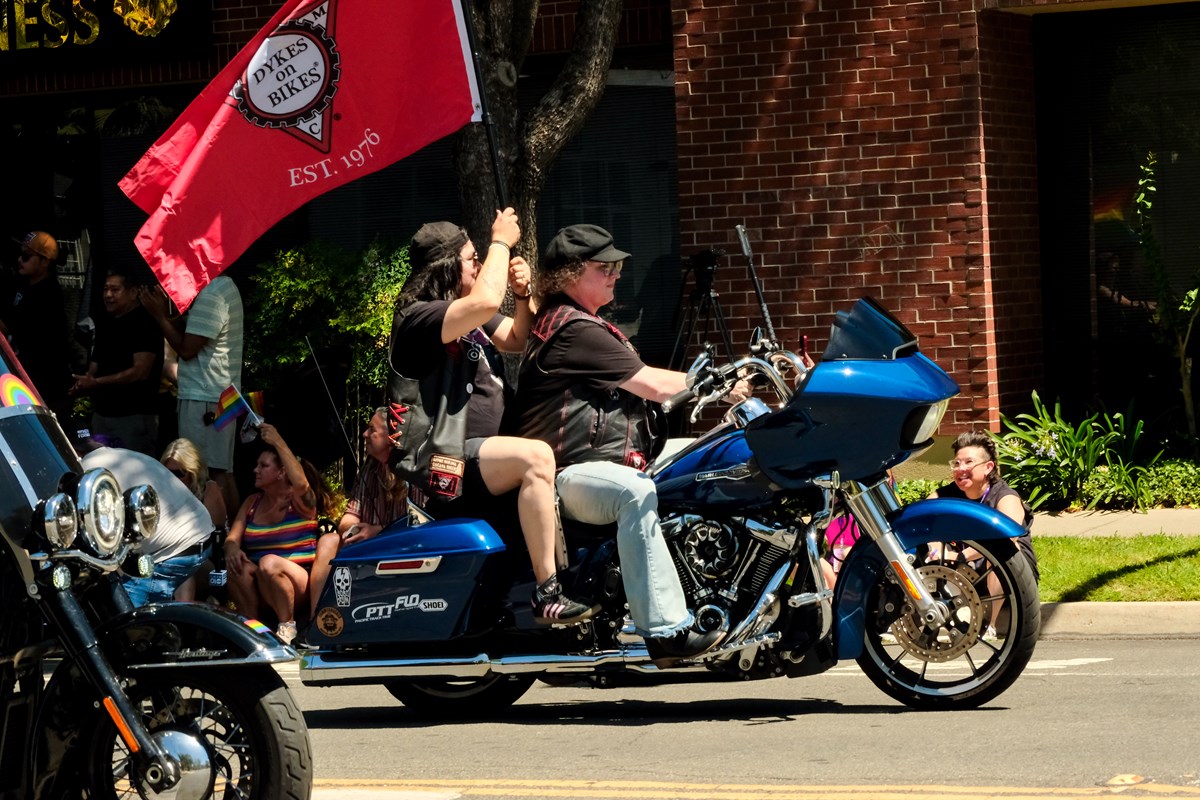 Michelle Reynolds and her partner ride in the Sacramento Pride March, flying a flag for San Francisco Dykes on Bikes on June 15, 2026.