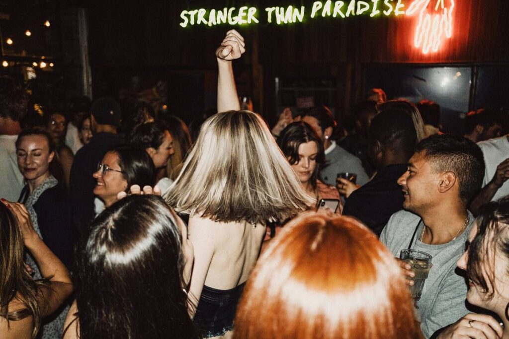 People inside a nightclub with neon lights.