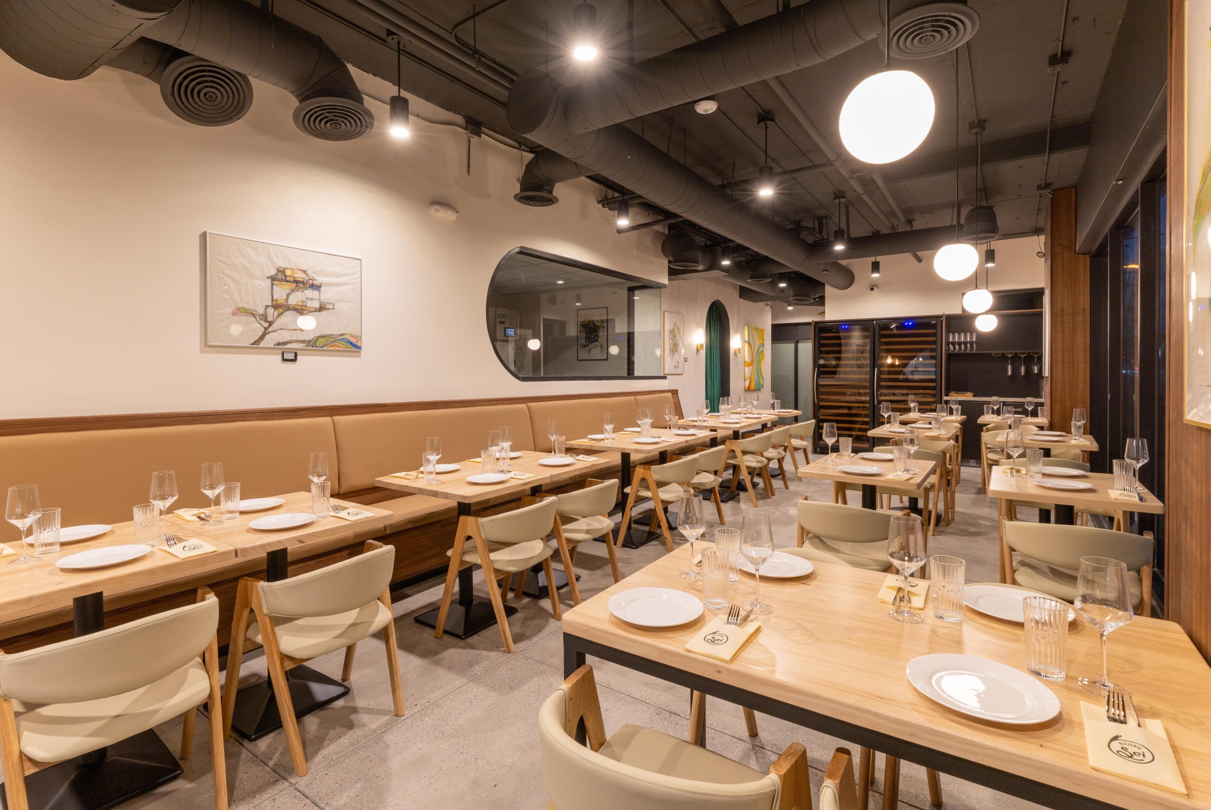 Dining room at Pizzeria Sei with blonde wood tables.